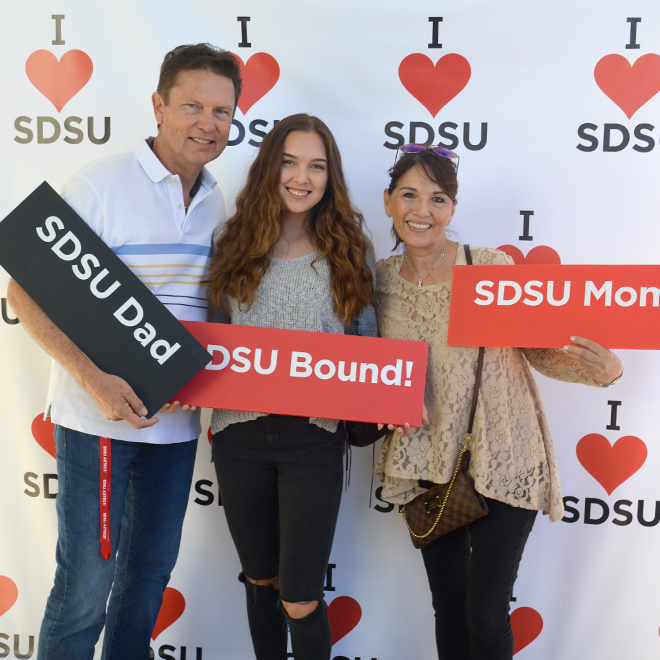 Family holding up SDSU signs.